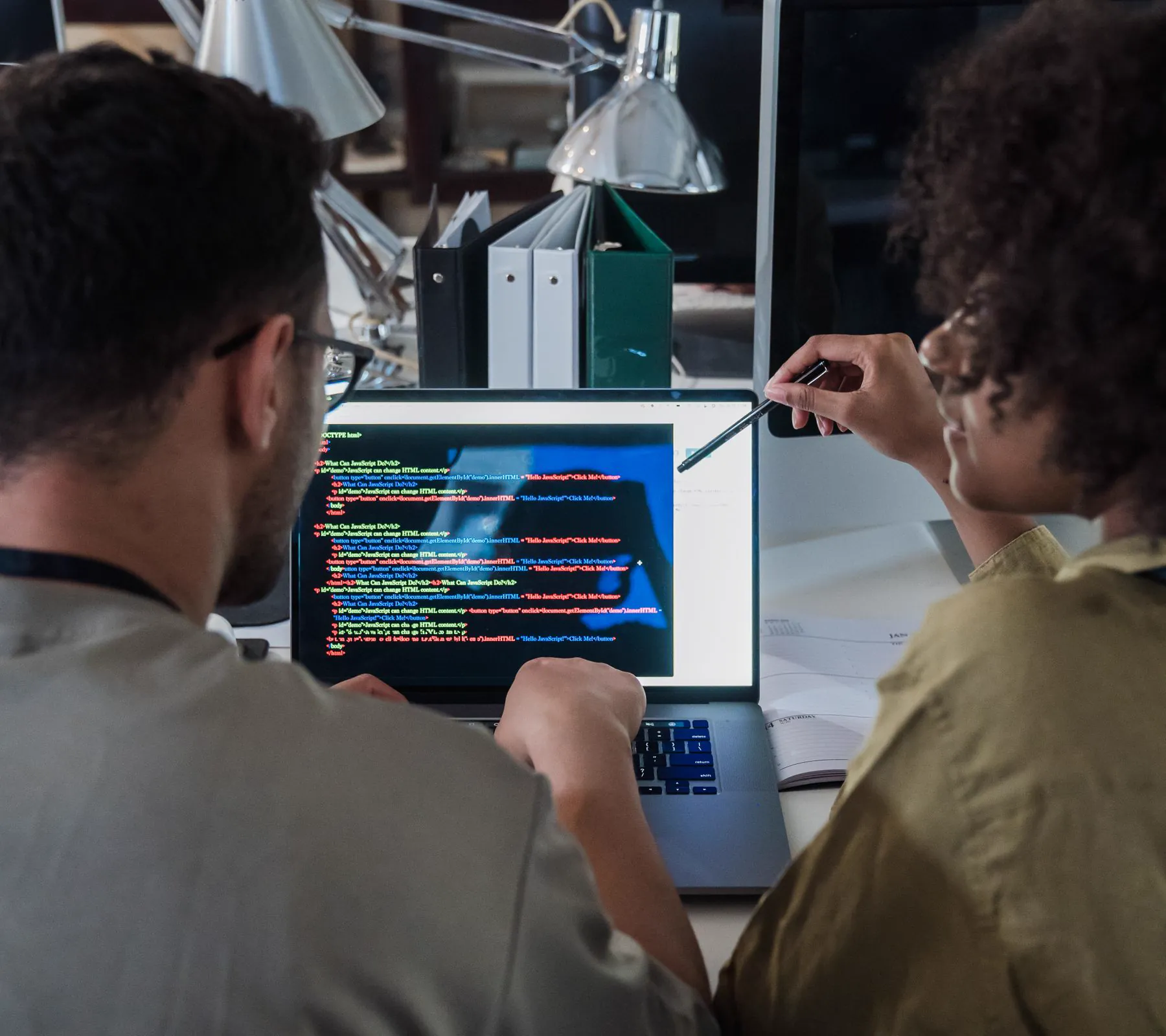 Two software engineers reviewing code together at a laptop